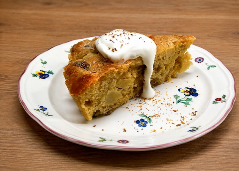 Photo of a KATZ Farm fennel pollen apple cake slice topped with a dollop of cream