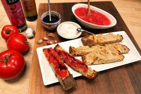 Photo of a plate with tomato toasts next to some of the recipe's ingredients